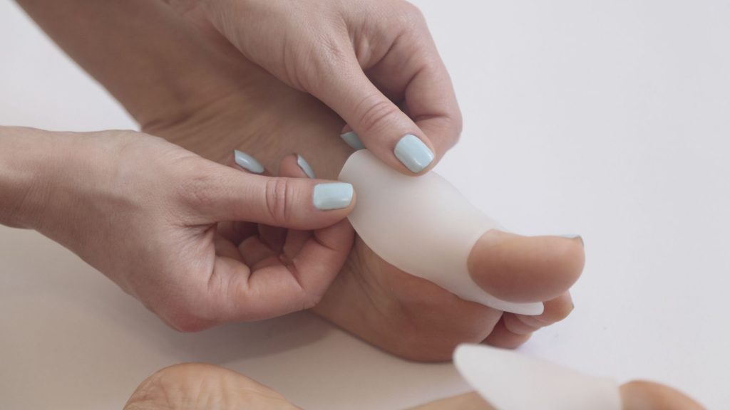 A woman using a pad on big toe to relieve bunion pain 